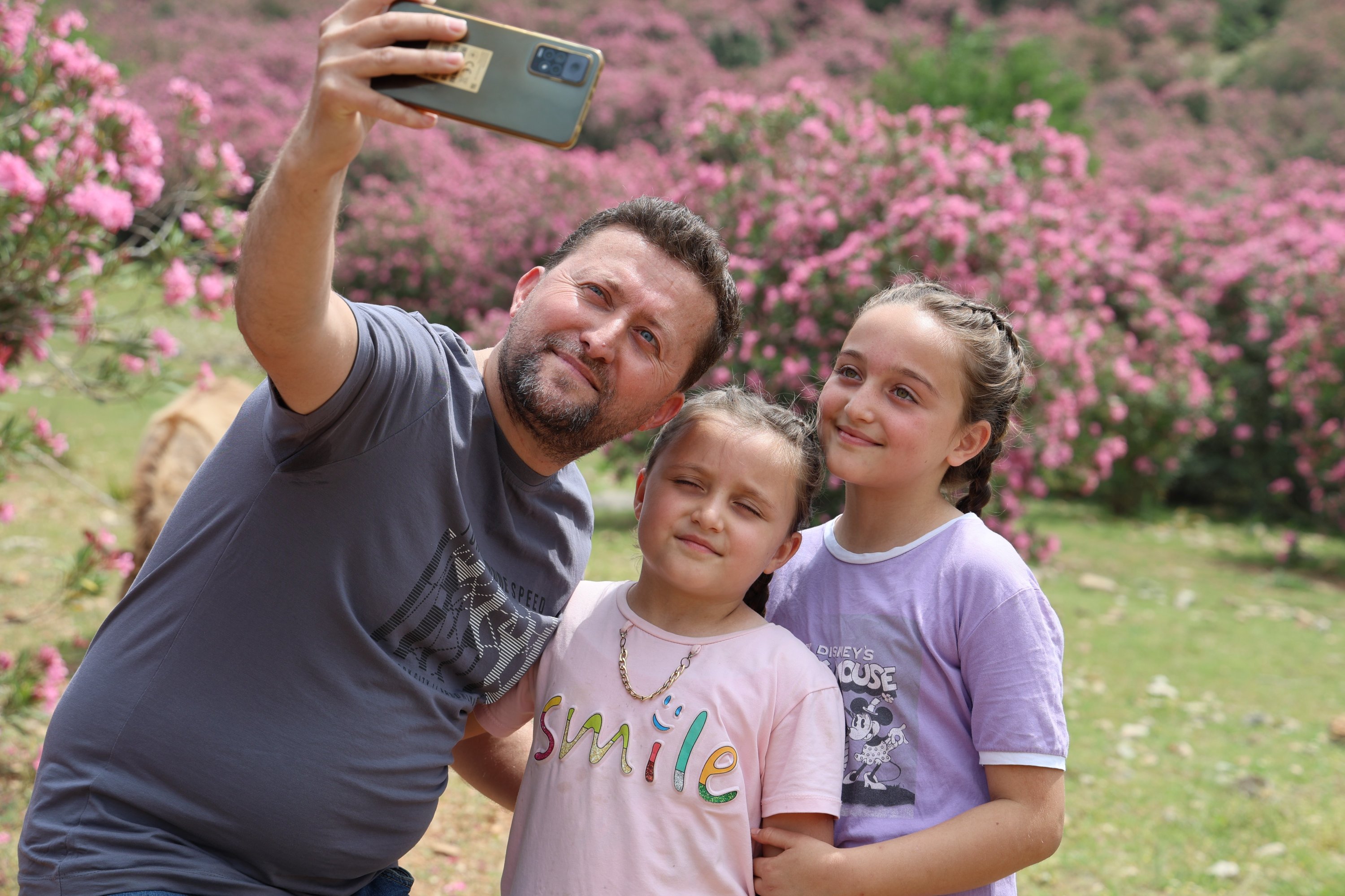 326045 Visitors take photos of oleander flowers in the Kozan district of Adana, western Türkiye, May 2, 2024. (IHA Photos)