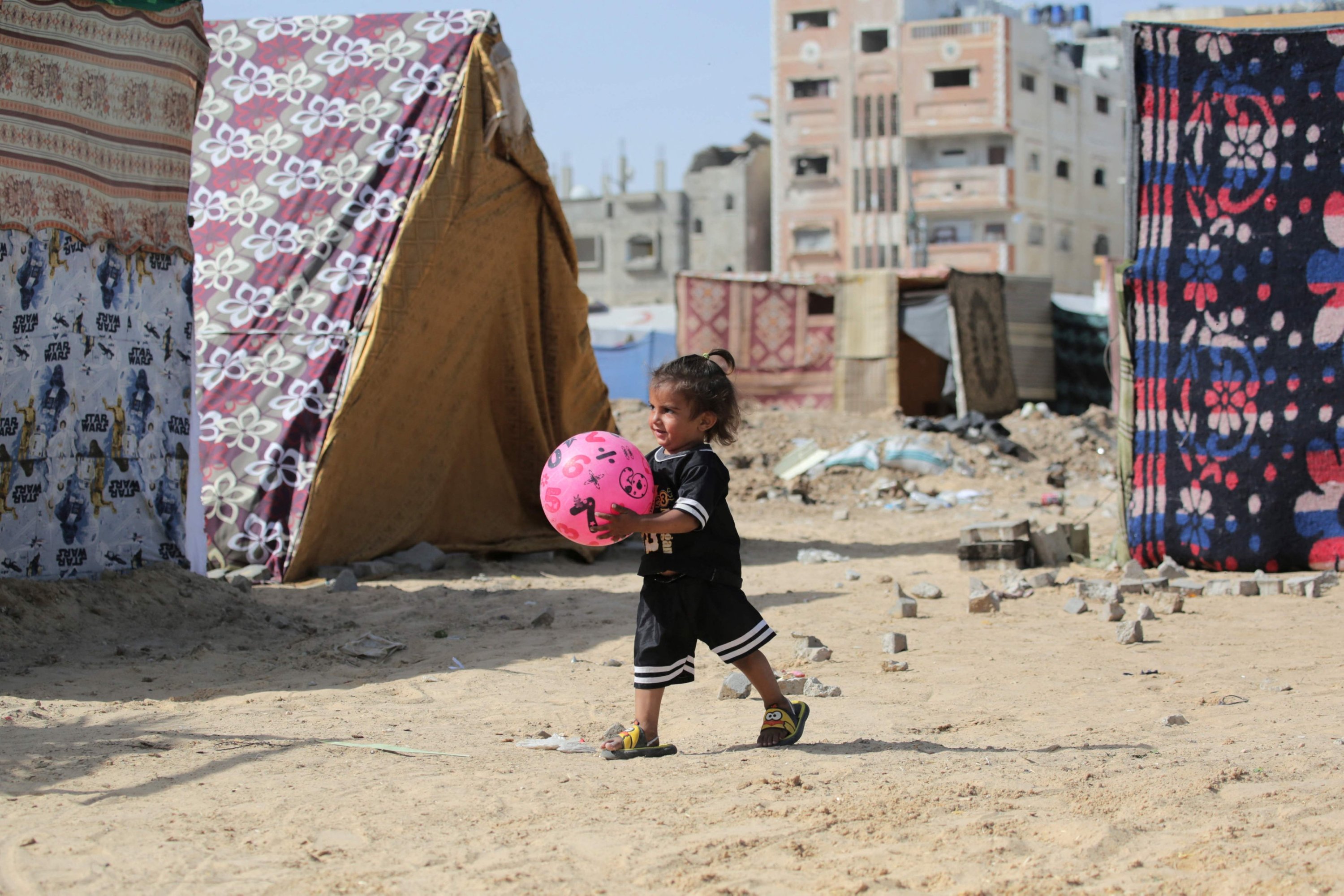 327451 A Palestinian child plays with a ball amid tents at an area housing internally displaced people, in Nuseirat in the central Gaza Strip, Palestine, May 10, 2024. (AFP Photo)