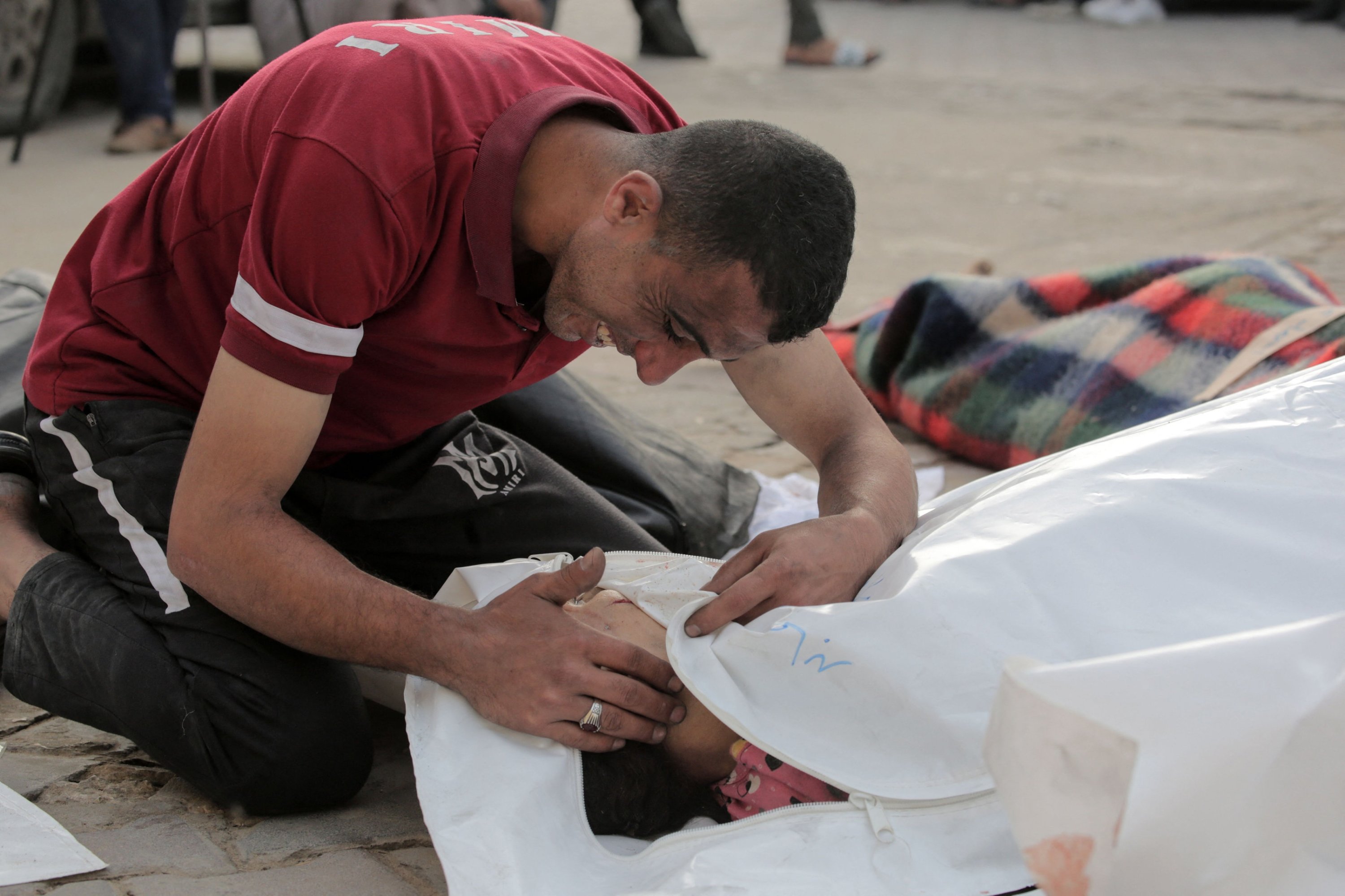 327800 A Palestinian man reacts over the body of a child killed in Israeli bombardment, in the yard of the Al-Aqsa Martyrs Hospital in Deir al-Balah in the central Gaza Strip on May 11, 2024. (AFP Photo)