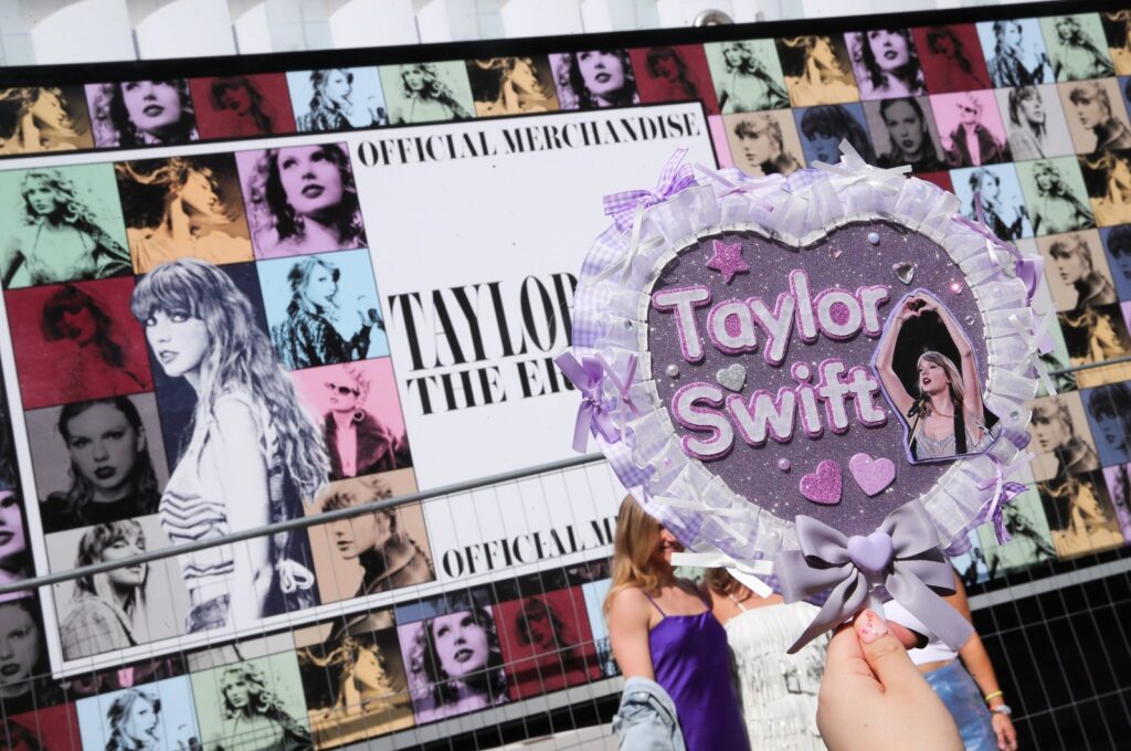 A Taylor Swift fan takes a picture of a handmade sign next to the poster of Taylor Swift's "Eras Tour" first concert in Europe, at the Paris La Defense Arena, Nanterre, Paris, France, May 9, 2024. (EPA Photo)