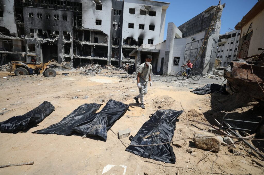 Civil defense crews recover the bodies of Palestinians buried under the rubble during the Israeli bombing of Al-Shifa Hospital, in Gaza City, Palestine, May 7, 2024. (AA Photo)