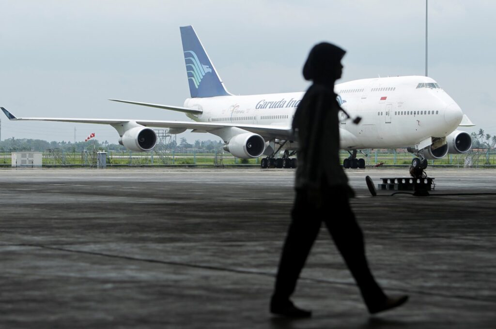 A GMF AeroAsia employee walks past a Garuda Indonesia Boeing 747 aircraft on the tarmac at GMF AeroAsia's hangar, Tangerang, Indonesia, Jan. 12, 2011. (Reuters File Photo)