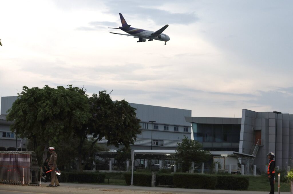 A Thai police officer and airport security guard secured the entrance to the runway after a flight from London to Singapore diverted an emergency landing at Suvarnabhumi International Airport in Samut Prakan province, Thailand, on May 21, 2024. (EPA Photo)