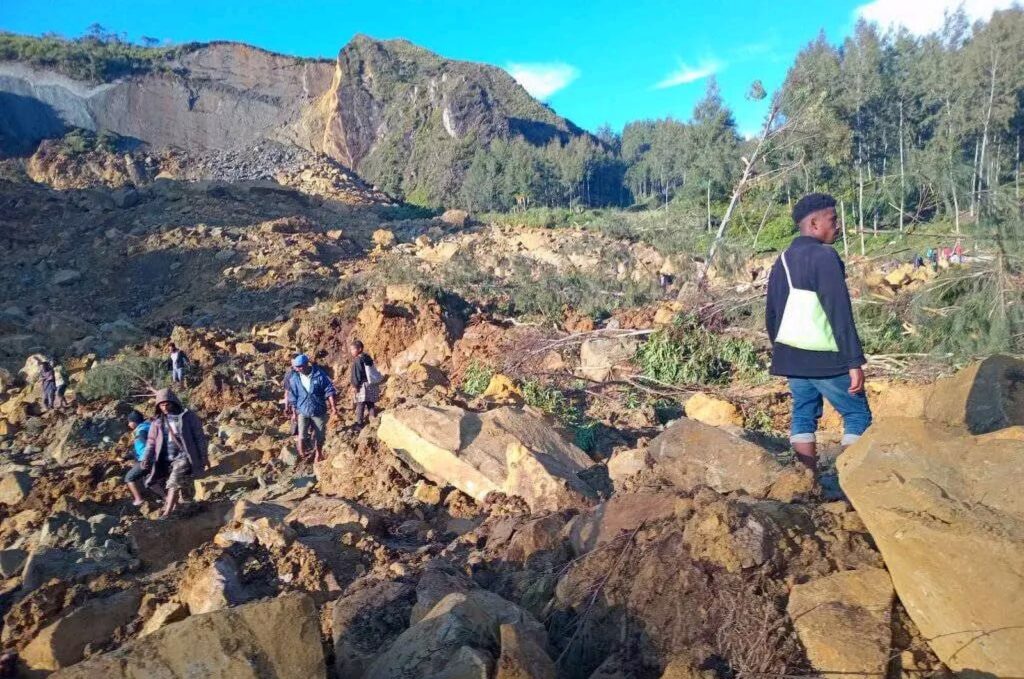 People walk with their belongings in the area where a landslide hit the village of Kaokalam, Enga province, Papua New Guinea, May 24, 2024. ()