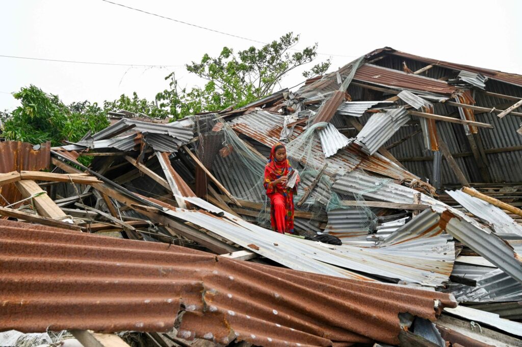 A girl walks amid her damaged house after cyclone Remal's landfall in Patuakhalim Bangladesh, May 28, 2024. (AFP Photo)