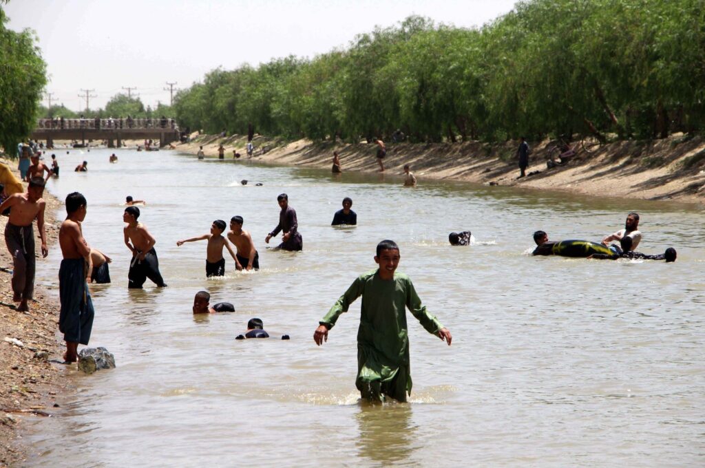 Afghan youths cool off in a canal during the current heat wave, Kandahar, Afghanistan, May 31, 2024