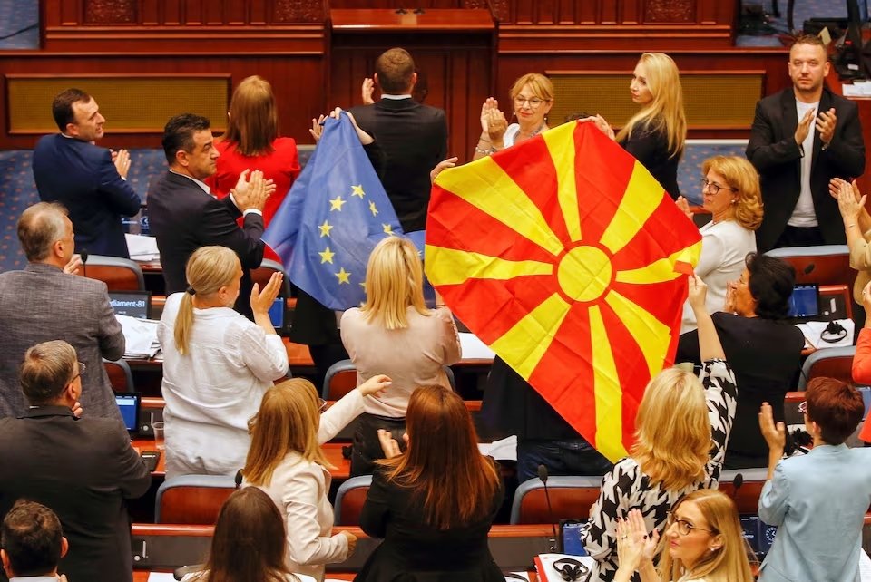 North Macedonian members of Parliament from the SDSM party, hold European Union and North Macedonian flags, during a parliamentary debate on a deal aimed at settling disputes with Bulgaria and clearing the way to EU membership, in Skopje, North Macedonia, July 16, 2022. (Reuters Photo)
