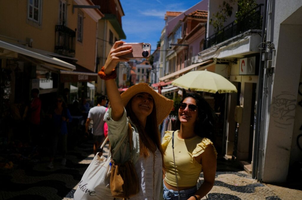 Tourists take a picture on a street in Cascais, Portugal, June 6, 2022. (Reuters Photo)