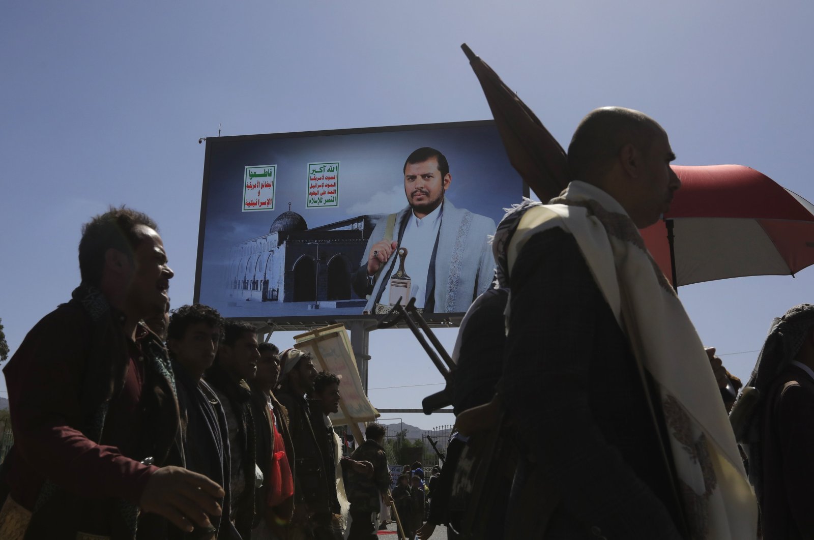 Houthi supporters pass a billboard featuring Houthis' leader Abdul-Malik al-Houthi, during a protest against the U.S. and Israel, and in solidarity with the Palestinian people, Sanaa, Yemen, June 7, 2024. (EPA Photo)