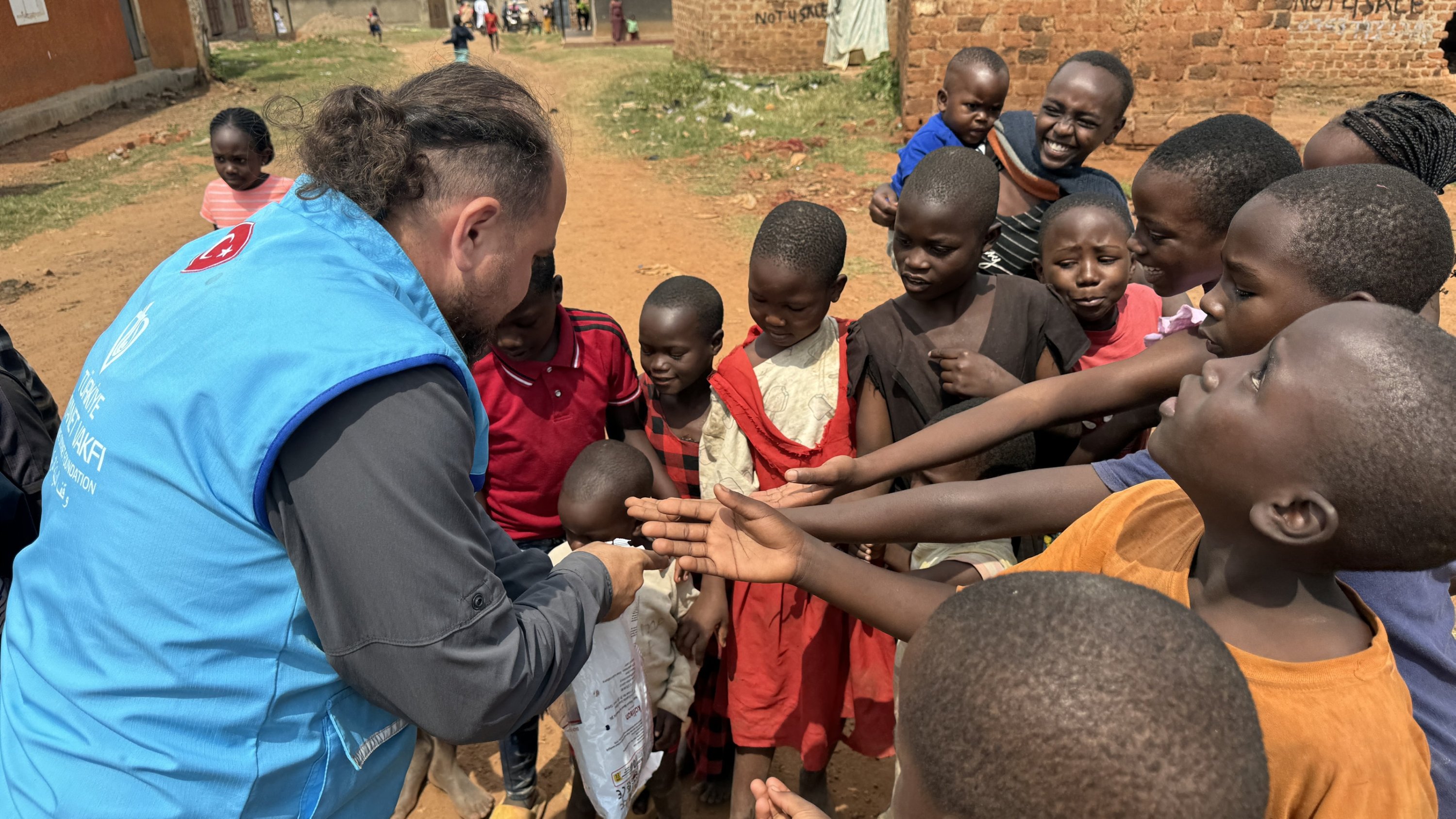 332905 A staff member of Diyanet distributes aid and meat from sacrificial animals, Uganda, June 16, 2024. (AA Photo)