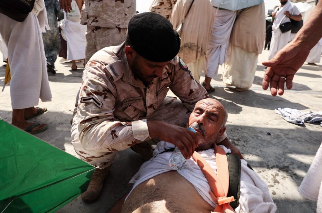 A man affected by the scorching heat is helped by a member of the Saudi security forces in Mina, near the holy city of Mecca, Saudi Arabia, June 16, 2024. (AFP Photo)