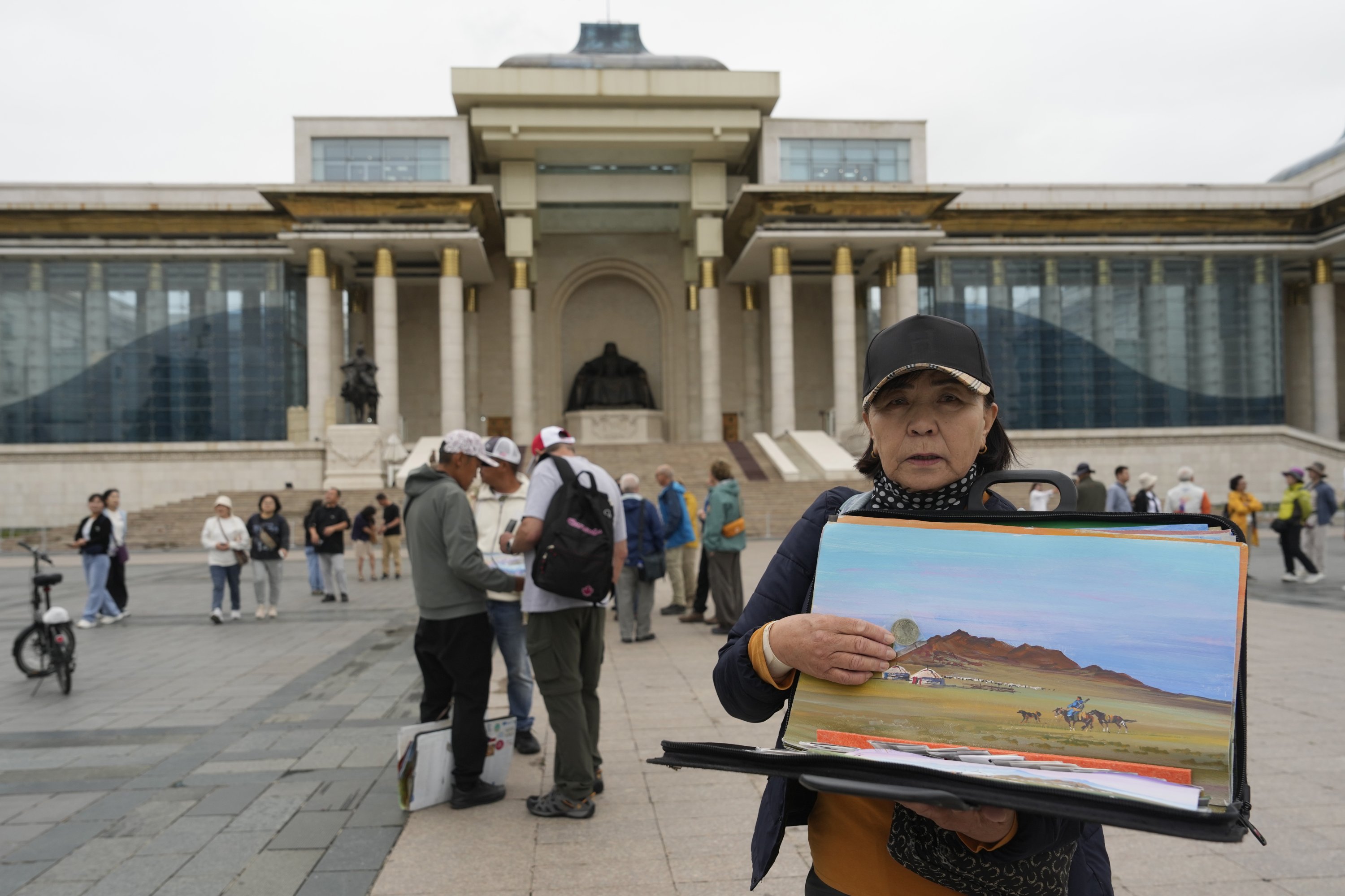 335121 A woman sells artwork depicting rural Mongolia, on Sukhbaatar Square in Ulaanbaatar, Mongolia, June 27, 2024. (AP Photo)