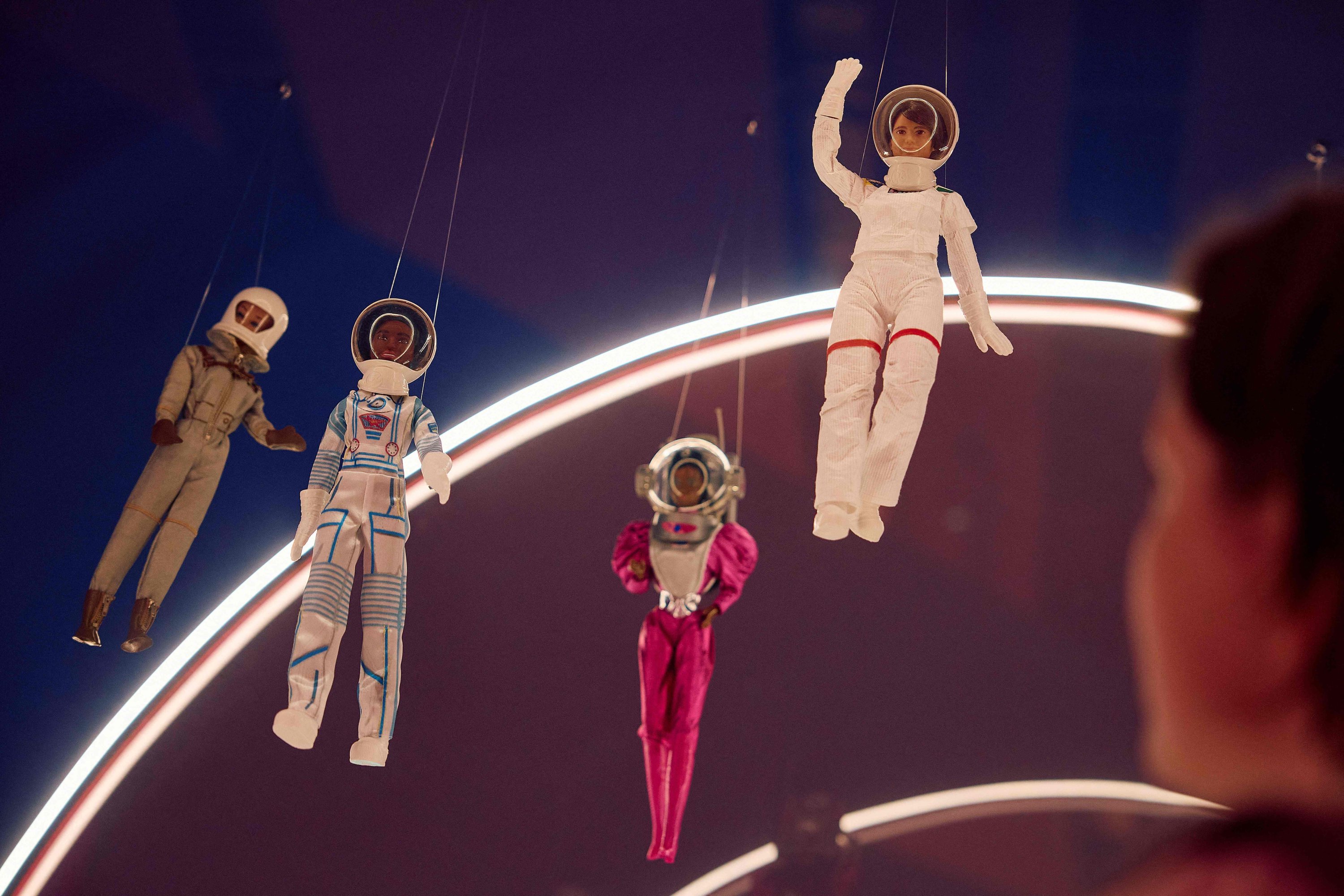 335543 A gallery assistant looks at a Barbie doll taken to space by European Space Agency (ESA) astronaut and Europe's first female commander of the International Space Station Samantha Cristoforetti (top R) during the