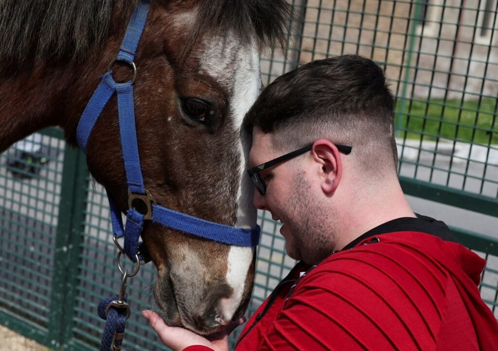 Matteo Santopadre, a former shooting champion who remained in a coma for months after a car accident, attends a hippotherapy session to regain his mobility, Rome, Italy, March 13, 2024. (Reuters Photo)