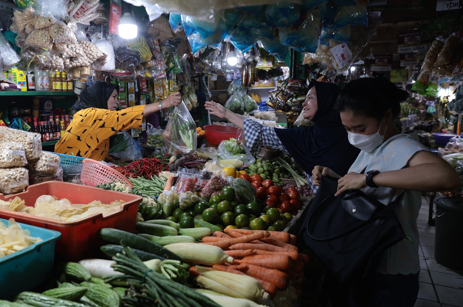 A produce vendor serves customers at a market, Depok, Indonesia, July 1, 2024. (EPA Photo)
