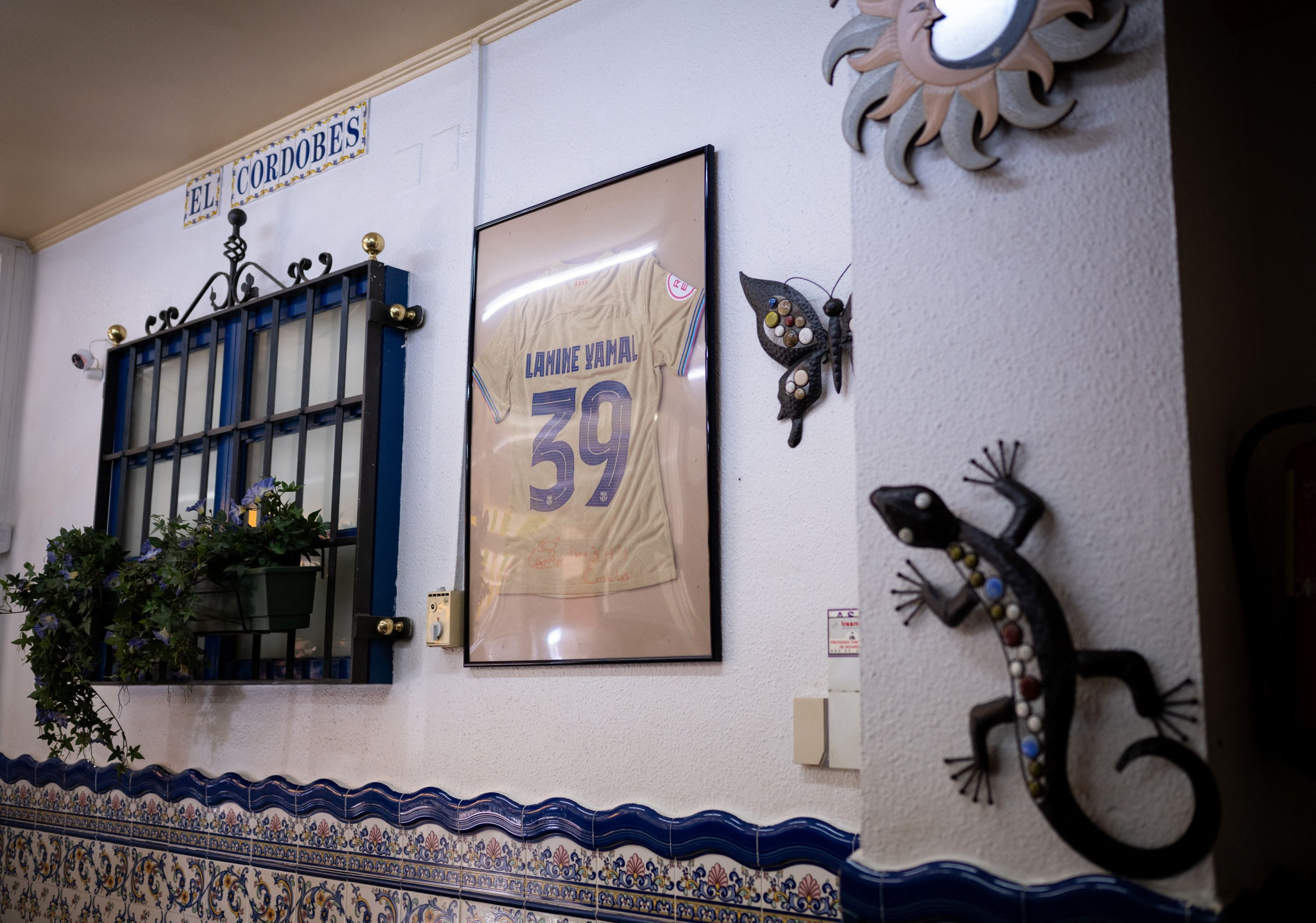 336491 A framed and signed jersey of Spain's forward Lamine Yamal hangs on a wall of El Cordobes bar, in Rocafonda, the neighborhood where Lamine Yamal grew up, Mataro, near Barcelona, Spain, July 11, 2024. (AFP Photo)