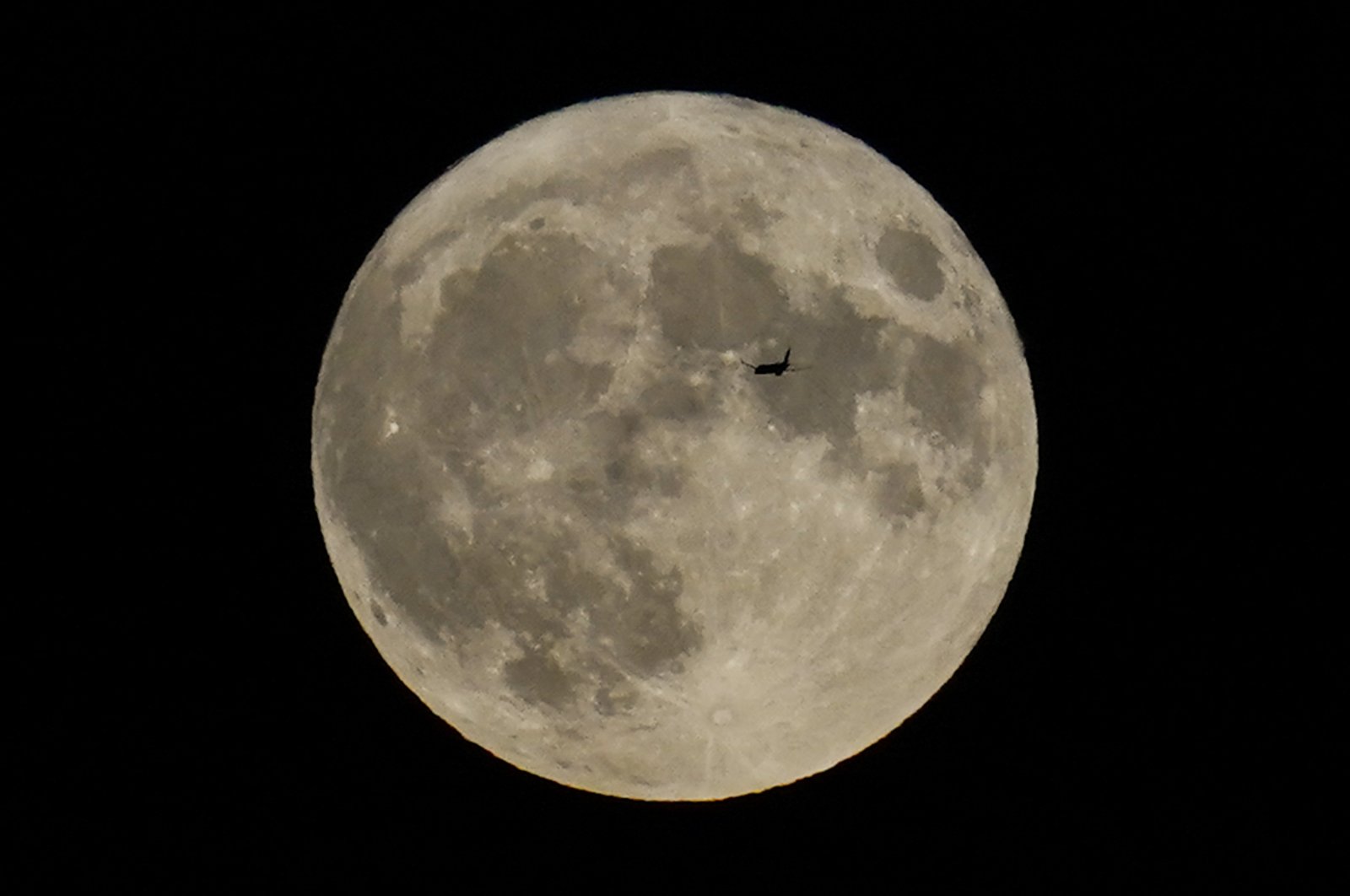 A plane passes in front of a full moon, Chicago, U.S., Aug. 30, 2023. (AP Photo)