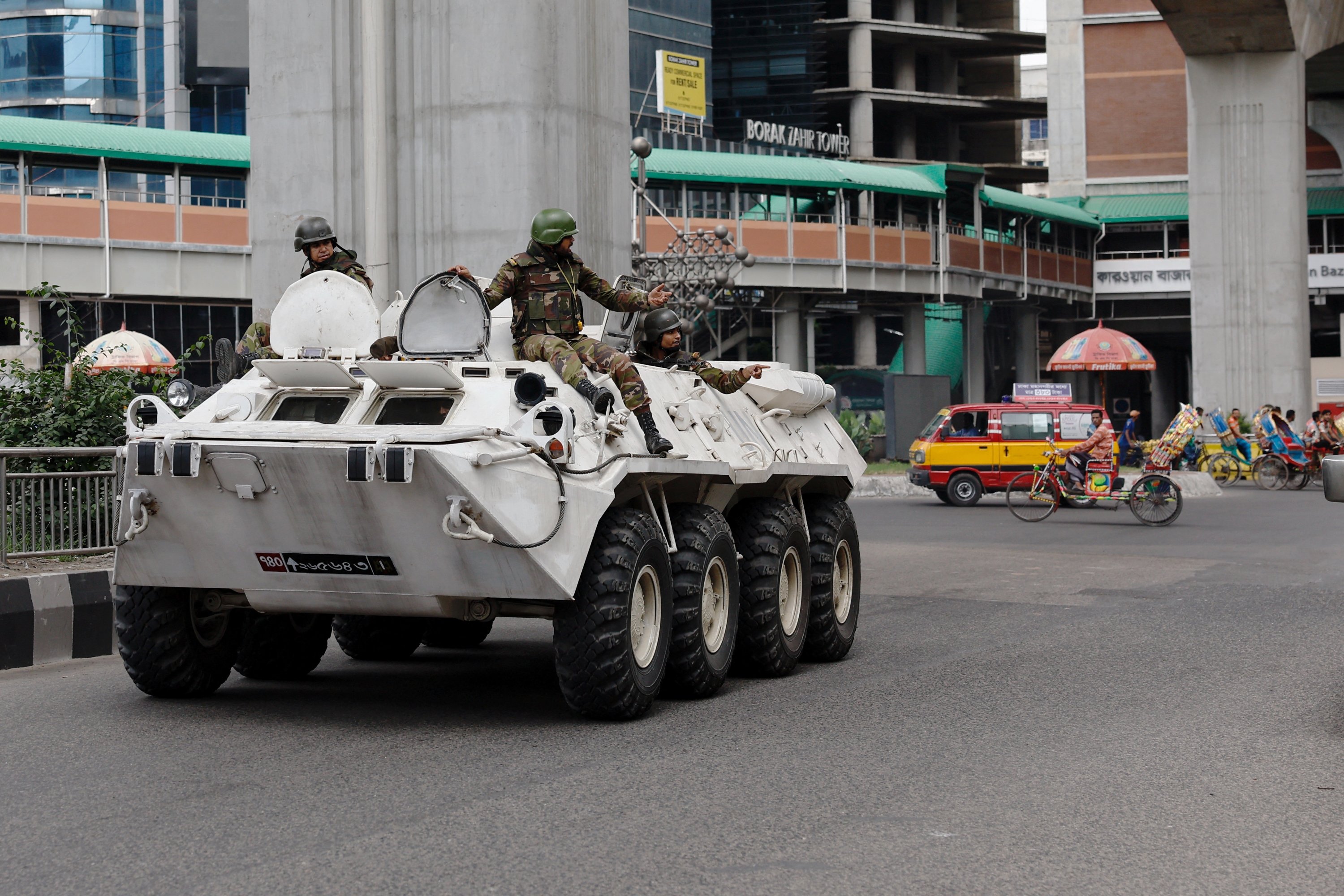 337736 Members of the Bangladesh Army gesture as they patrol in an armored vehicle on the second day of a curfew, in Dhaka, Bangladesh, July 21, 2024. (Reuters Photo)