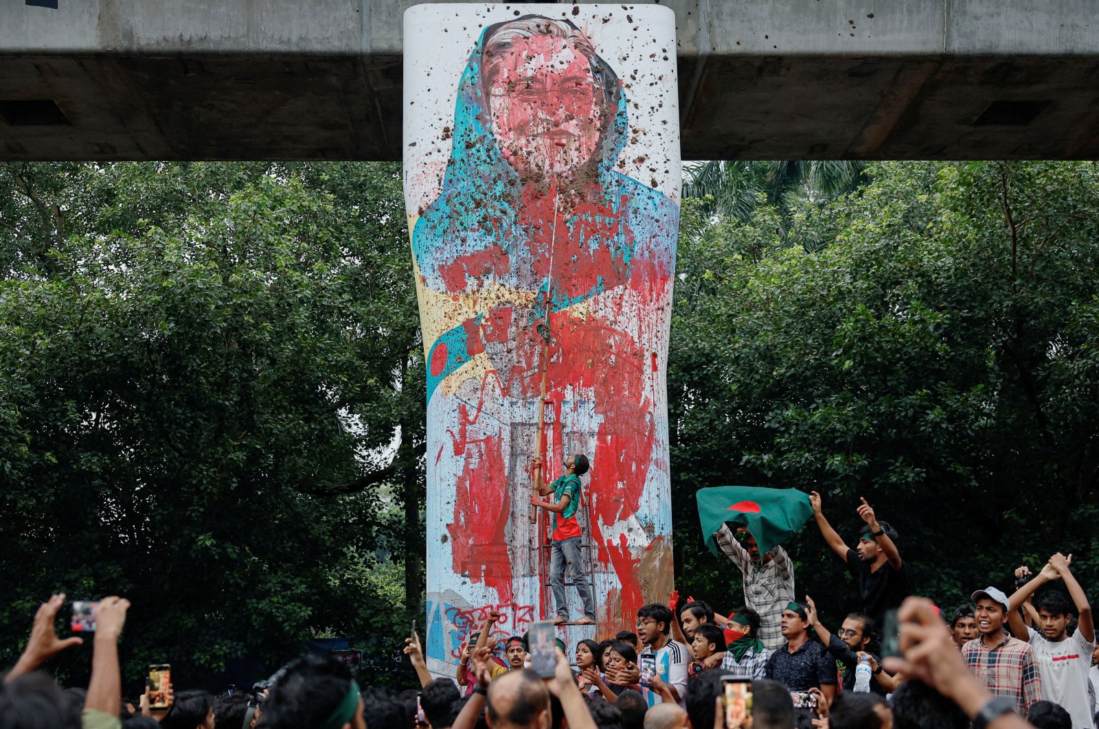 Protesters vandalize a mural of Bangladeshi Prime Minister Sheikh Hasina with paint and mud, demanding her resignation at the Teacher-Student Center (TSC) area of the University of Dhaka, Dhaka, Bangladesh, Aug. 3, 2024. (Reuters Photo)