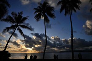 People watch the setting sun along the coast in Suva, Fiji, Dec. 16, 2022. (AFP Photo)