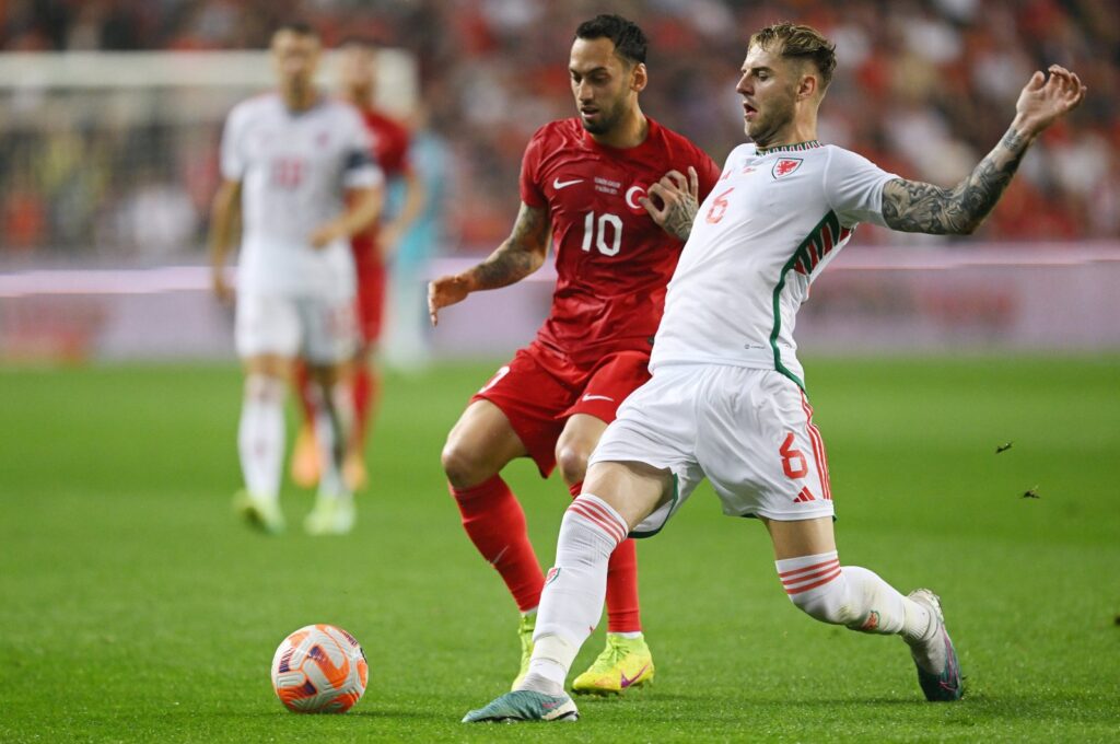 Türkiye's Hakan Çalhanoğlu (L) and Wales' Joe Rodon battle for possession during the UEFA EURO 2024 qualifying round Group D match, Samsun, Türkiye, June 19, 2023. (Getty Images Photo)