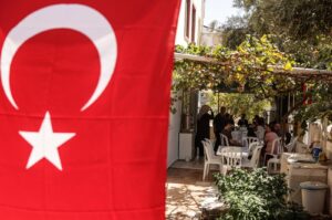 Relatives of Turkish American activist Ayşenur Ezgi Eygi, who was shot dead in the West Bank, sit in her grandfather's garden decorated with Turkish flags during a gathering to mourn her death, in the Didim district of Aydın, Türkiye, Sept. 11, 2024. (EPA Photo)