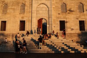 People rest on the stairs of the "Yeni Cami" (New Mosque) in the famous Eminönü neighborhood during sunset in Istanbul, Türkiye, Aug. 15, 2024. (EPA Photo)