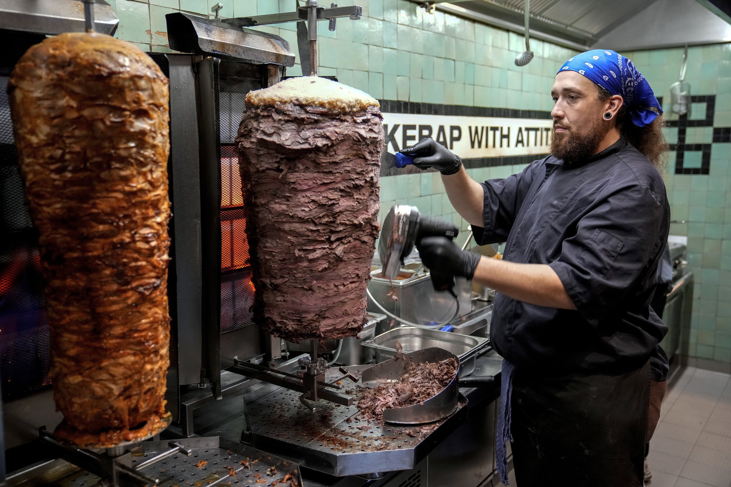 346801 Döner chef Hvesley Silva cuts döner kebab in a restaurant in Berlin, Germany, Sept. 16, 2024. (AP Photo)