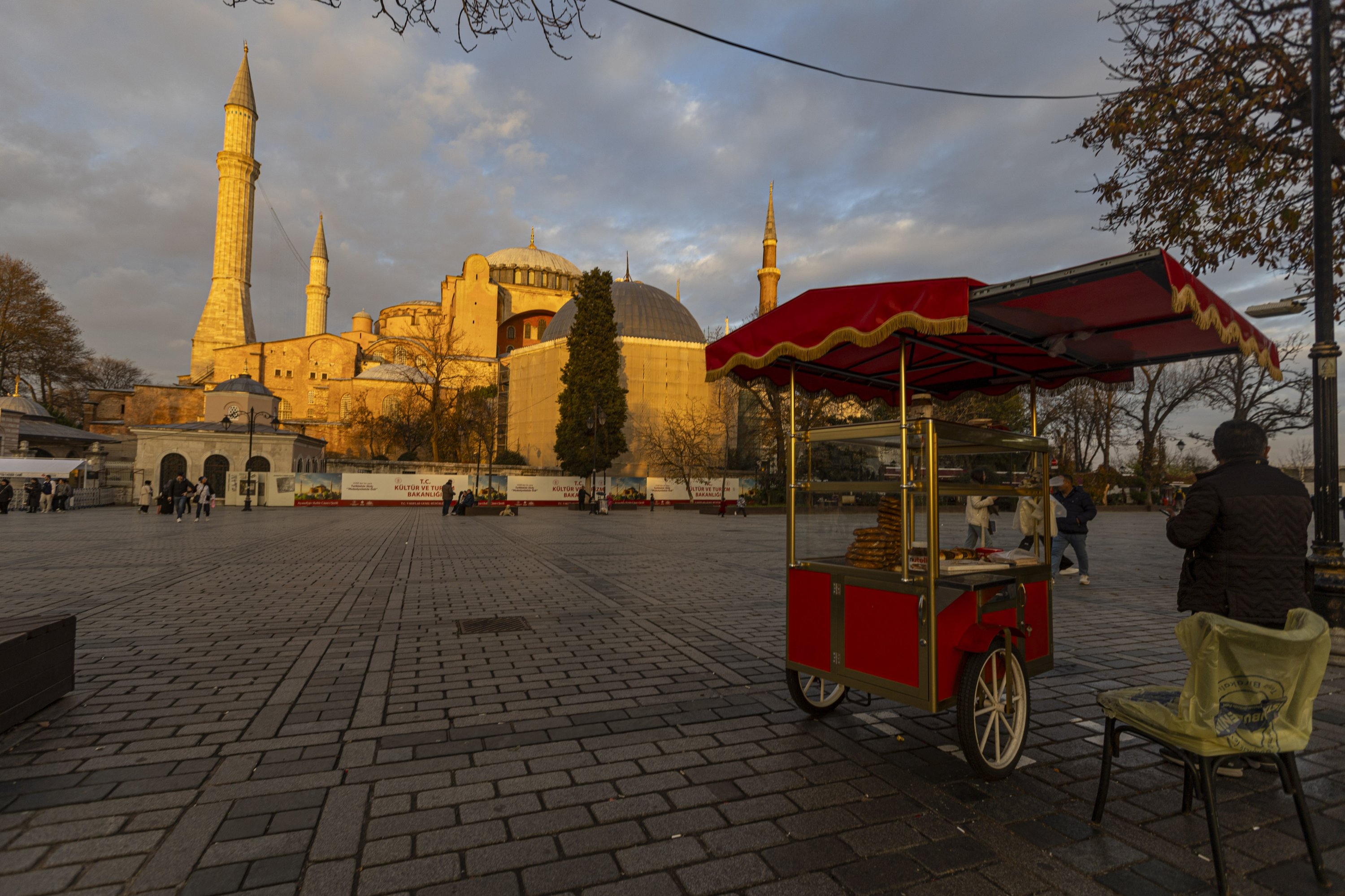 347765 A simit seller is seen with the Hagia Sophia Grand Mosque in the background, in Sultanahmet Square, Istanbul, Türkiye, Dec. 22, 2023 (Getty Images Photo)