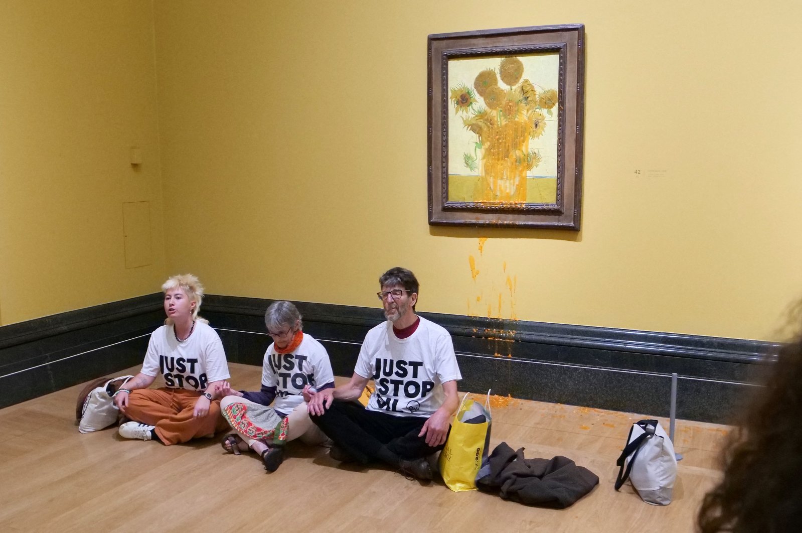 A handout picture from the Just Stop Oil climate campaign group shows three activists sitting on the floor under Vincent Van Gogh's "Sunflowers" in central London, U.K., Sept. 27, 2024. (AFP Photo)