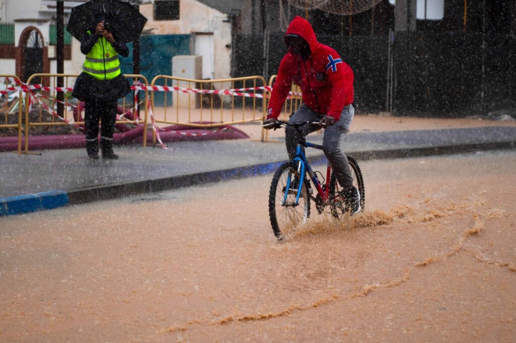A man rides a bicycle down a flooded street, Campanillas, Malaga, Spain, Nov. 13, 2024. (AFP Photo)