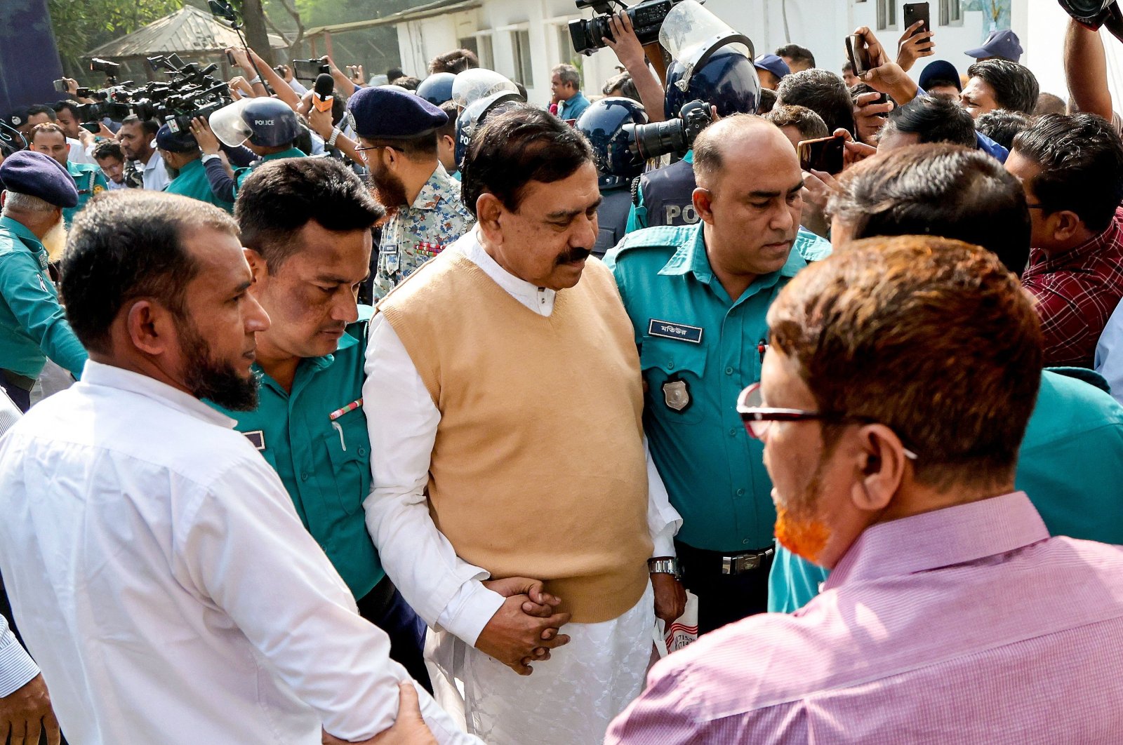 Police personnel escort detainee Shajahan Khan (C), a member of Bangladesh's ousted former Prime Minister Sheikh Hasina's Awami League party, to the country's International Crimes Tribunal (ICT) court, Dhaka, Bangladesh, Nov. 18, 2024. (AFP Photo)