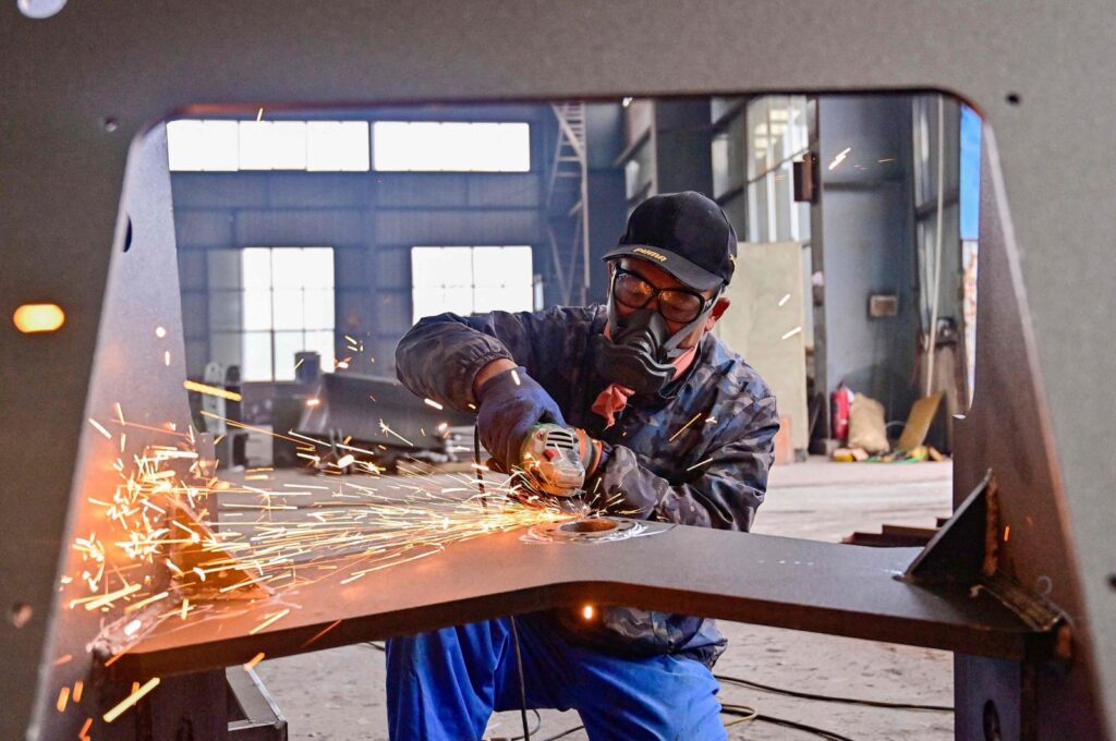 A worker works on a loader production line at a factory in Qingzhou, in eastern China's Shandong province, Nov. 15, 2024. (AFP Photo)