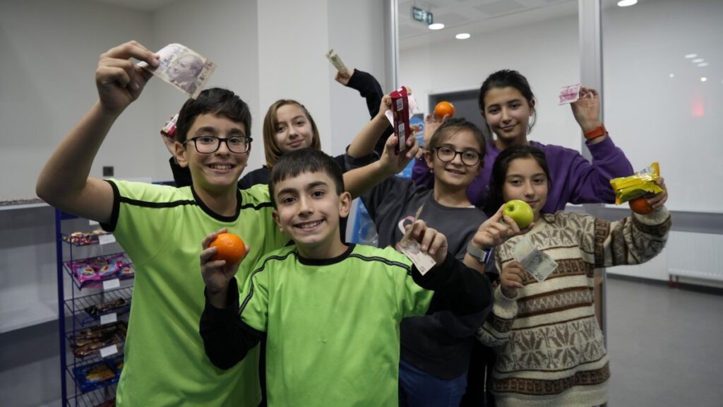 Students pose with canteen products and money at the Mustafa Canlı Science and Art Center in Gümüşhane, northern Türkiye, Dec. 11, 2024. (IHA Photo)