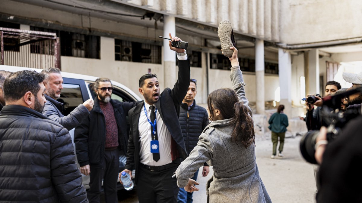 An angry woman looking for her missing brother and two of her cousins waves a shoe in front of the car of U.N.'s special envoy to Syrian during a visit at the Sadnaya prison in Damascus, Dec. 16, 2024. (AFP Photo)
