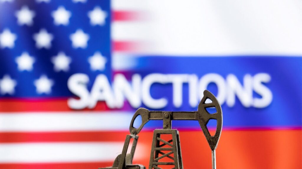 A model of a pump jack is seen in front of the displayed word "Sanctions" and U.S. and Russia flag colors in this illustration created on March 8, 2022. (Reuters Photo)