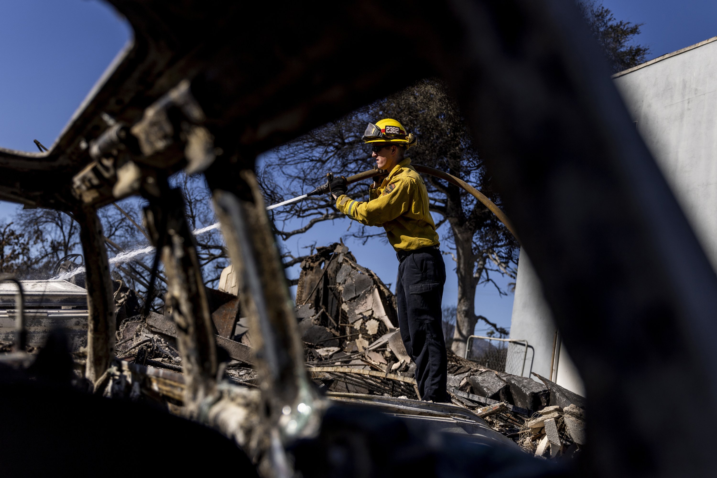 363800 A firefighter hoses down a hotspot at a home destroyed by the Eaton Fire in Altadena, California, U.S., Jan. 12, 2025. (AP Photo)