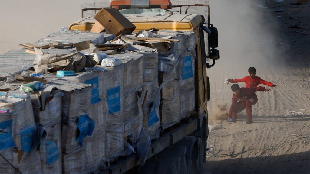 Palestinian children rush to collect aid on the road distributed by an aid truck, following a cease-fire, in Rafah, southern Gaza Strip, Palestine, Jan. 20, 2025. (Reuters Photo)