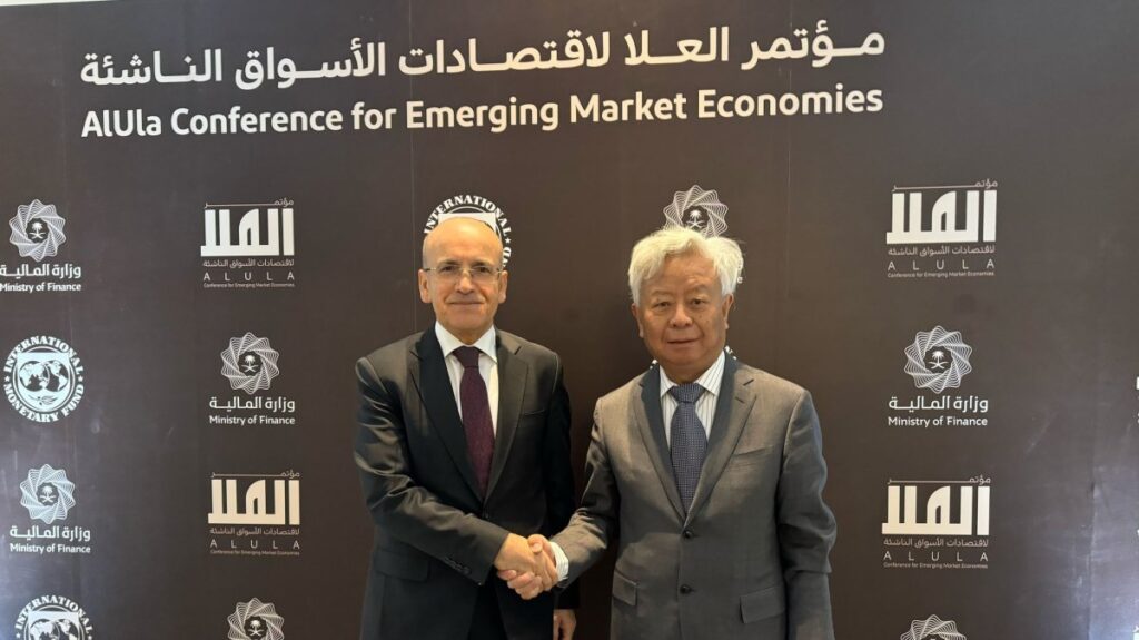 Treasury and Finance Minister Mehmet Şimşek (L) shakes hands with the president of the Asian Infrastructure Investment Bank (AIIB) Jin Liqun, Al-Ula, Saudi Arabia, Feb. 17, 2025. (DHA Photo)