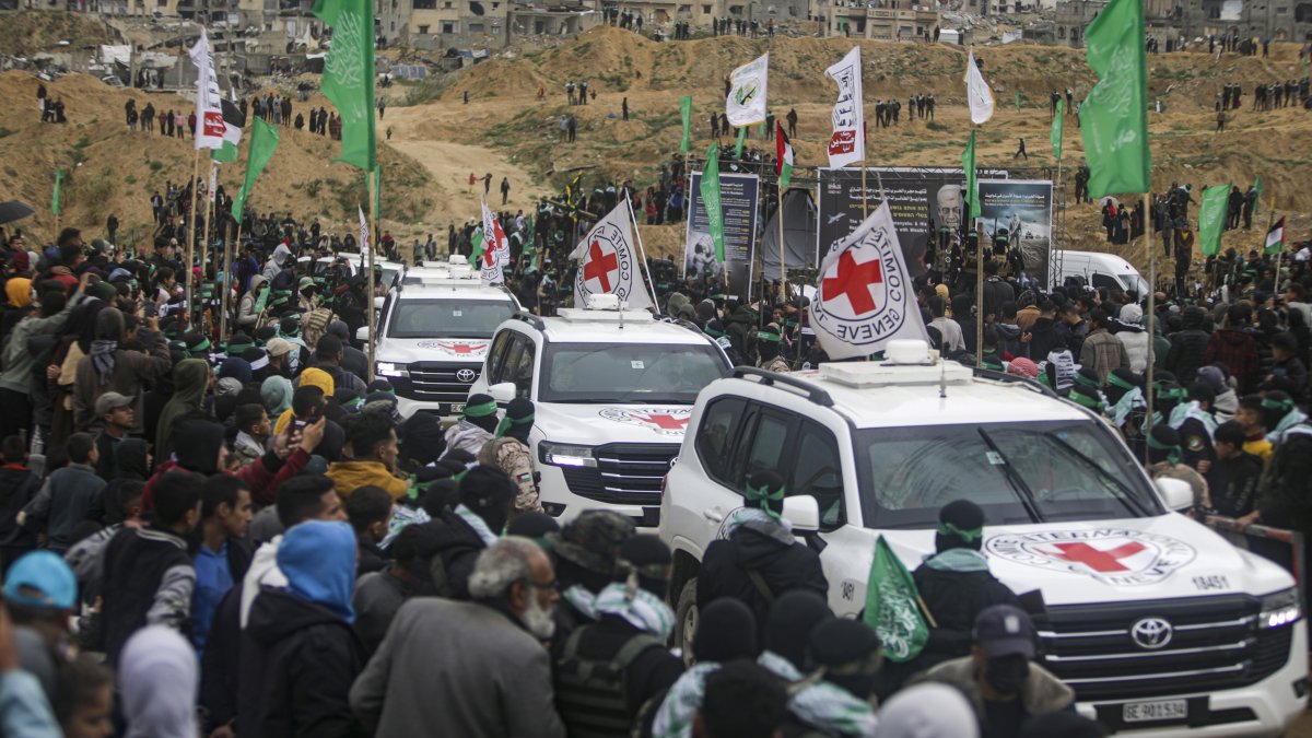 Red Cross vehicles arrive to collect the coffins containing the bodies of four Israeli hostages, including a mother and her two children, who had long been feared dead, to be handed over Hamas in Khan Younis, southern Gaza Strip, Thursday, Feb. 20, 2025. (AP Photo)