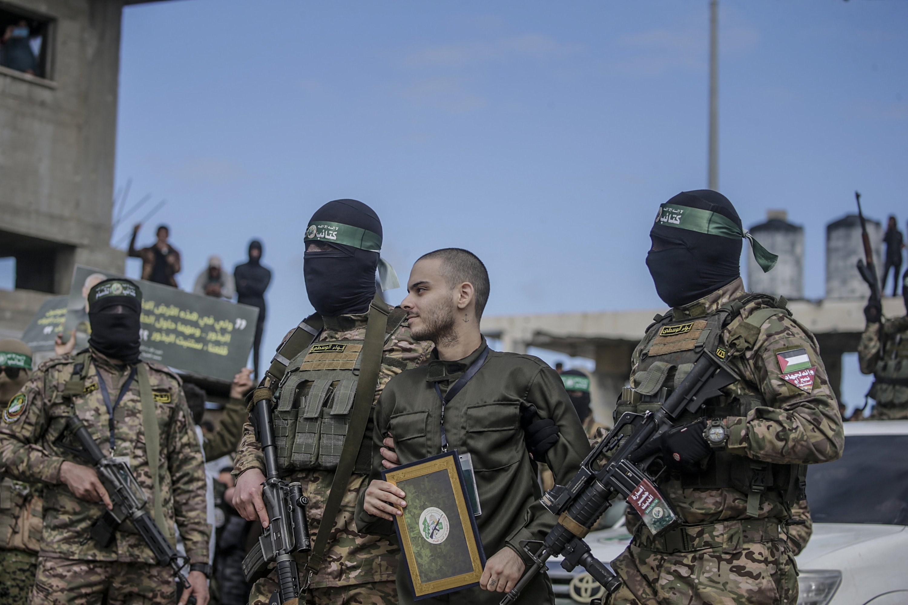 369828 Members of Hamas' Izz ad-Din al-Qassam Brigades escort Israeli hostage Omer Wenkert before handing him over to the Red Cross in Nuseirat refugee camp, central Gaza Strip, Palestine, Feb. 22, 2025. (EPA Photo)