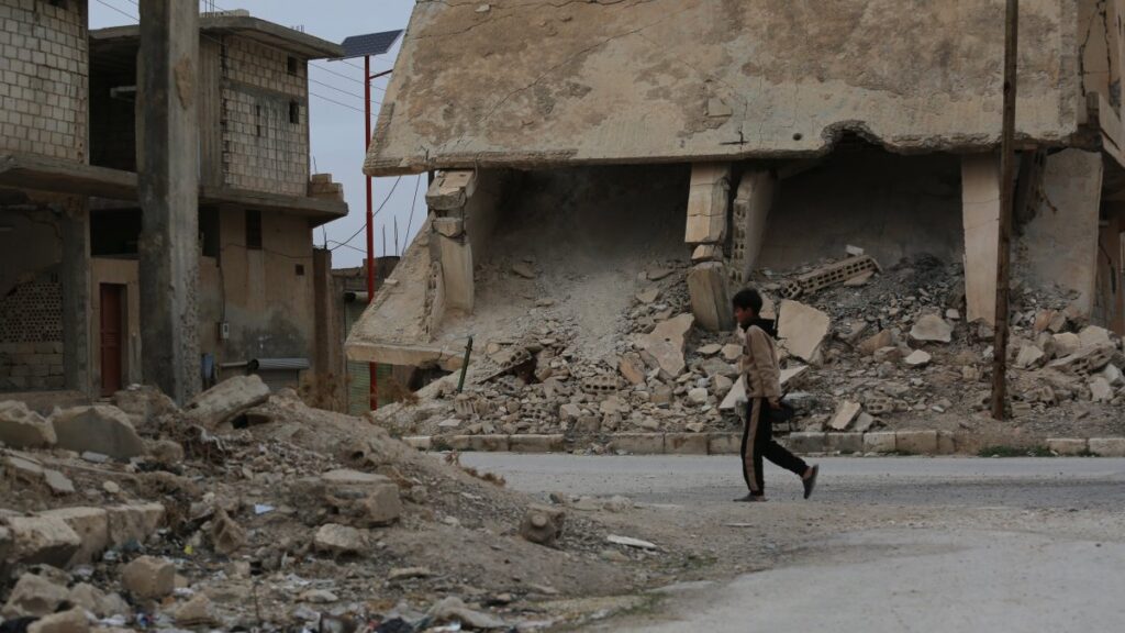 A boy walks along a street with destroyed buildings in the town of al-Hafta, east of Manbij, Syria, Feb. 25, 2025. (AA Photo)