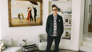 Mark Hoppus of Blink-182 poses by his painting "Crude Oil" ("Vettriano") by Banksy (2005), sold at auction on March 4 with some of the proceeds going to victims of the Los Angeles wildfires. (Sotheby's Handout via AP Photo)