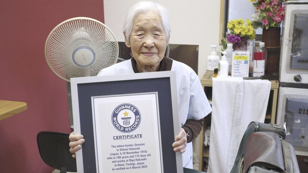 Shitsui Hakoishi, 108, poses for a photo with a Guinness World Records certificate recognizing her as the world's oldest female barber, at her shop in Nakagawa in Tochigi Prefecture, eastern Japan, March 5, 2025. (AP Photo)
