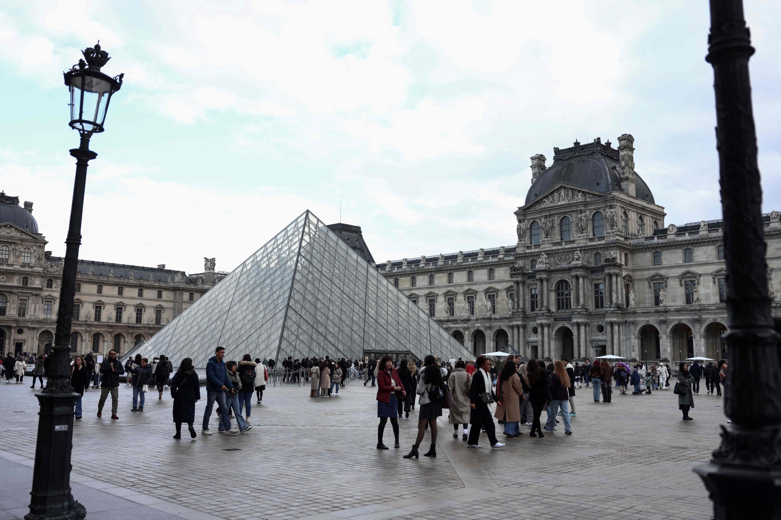 372258 Tourists stroll near the Louvre Pyramid, designed by Chinese American architect Ieoh Ming Pei, Paris, France, Feb. 28, 2025. (AFP Photo)