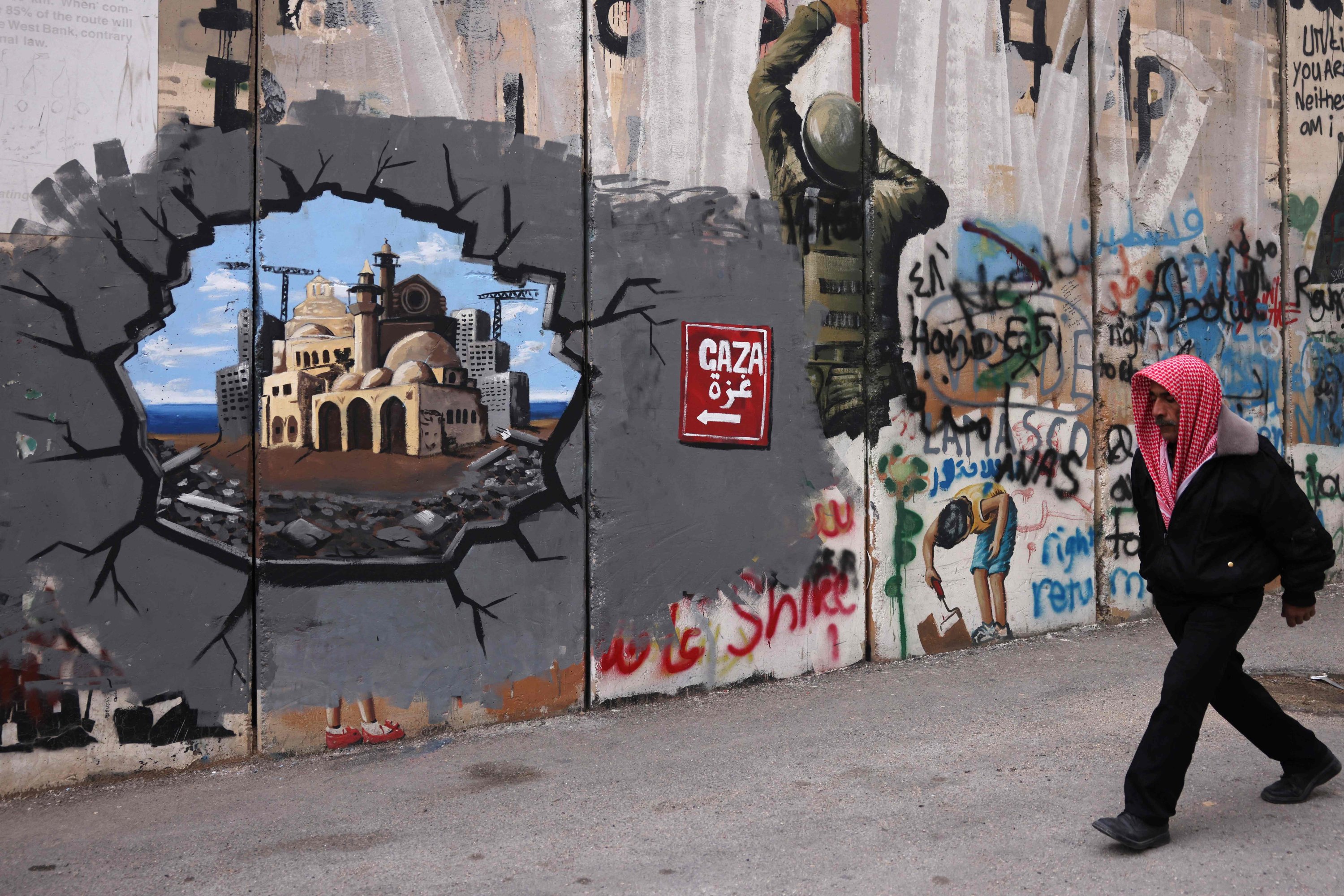 372561 A man walks past graffiti representing the reconstruction of Gaza on a section of Israel's separation barrier, Bethlehem in the occupied West Bank, Palestine, Feb. 12, 2025. (AFP Photo)