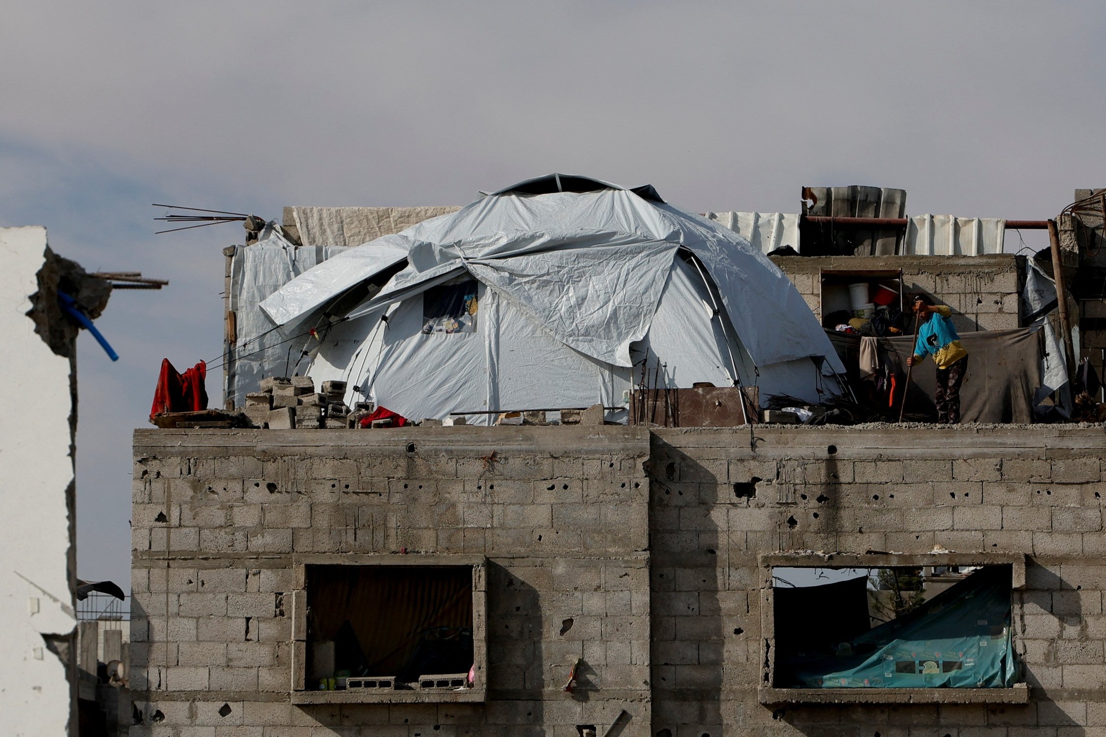 372984 A Palestinian stands beside a tent atop a house damaged during an Israeli offensive, Rafah, Gaza Strip, Palestine, March 13, 2025. (Reuters Photo)