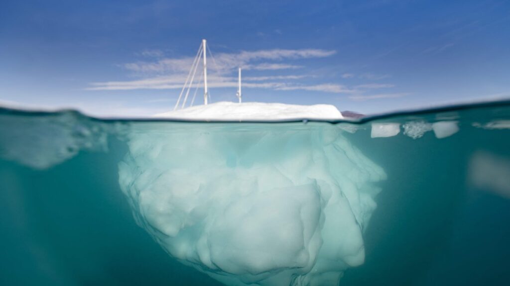 The Greenlandia expedition's sailing boat "Kamak" sails between icebergs released by glaciers around Milne Land in the Scoresby Sound Fjord, Greenland, Denmark, Aug. 15, 2023. (AFP photo)