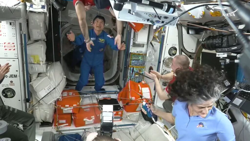 This screengrab made from a NASA livestream shows the SpaceX Dragon Crew-10 member astronaut Takuya Onishi (C) greets members of the International Space Station (ISS) crew shortly after docking at the ISS, March 16, 2025. (AFP Photo)