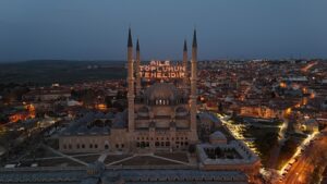 The illuminated mahya reading "Family is the foundation of society" hangs the minarets of Selimiye Mosque, Edirne, Türkiye, March 17, 2025. (IHA Photo)